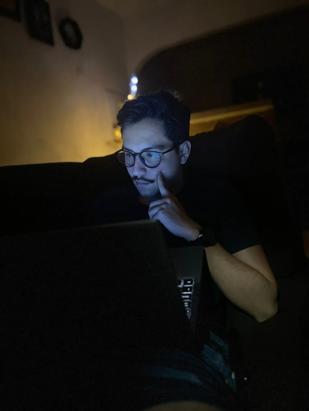 Carlos Espetia trabajando de noche frente a su portátil, iluminado por la pantalla.